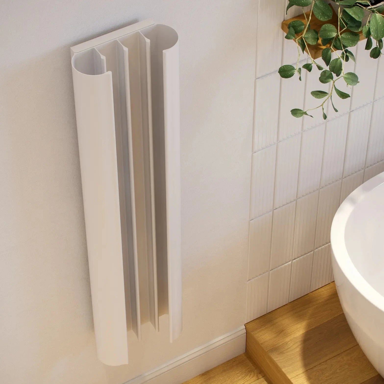 A white, loop-shaped heated towel rail mounted on a wall next to a bathtub with curved fins extending from its base.